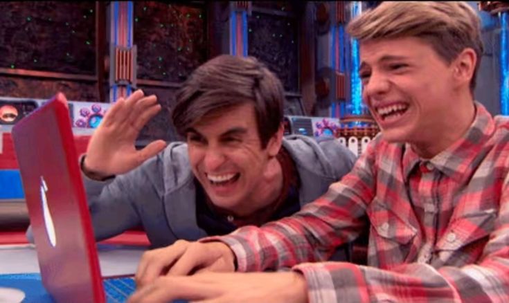 Two people laughing together at a laptop